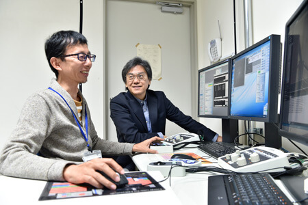 Prof. Kato (left) and Prof. Namba operating the CRYO ARM™ from a separate room